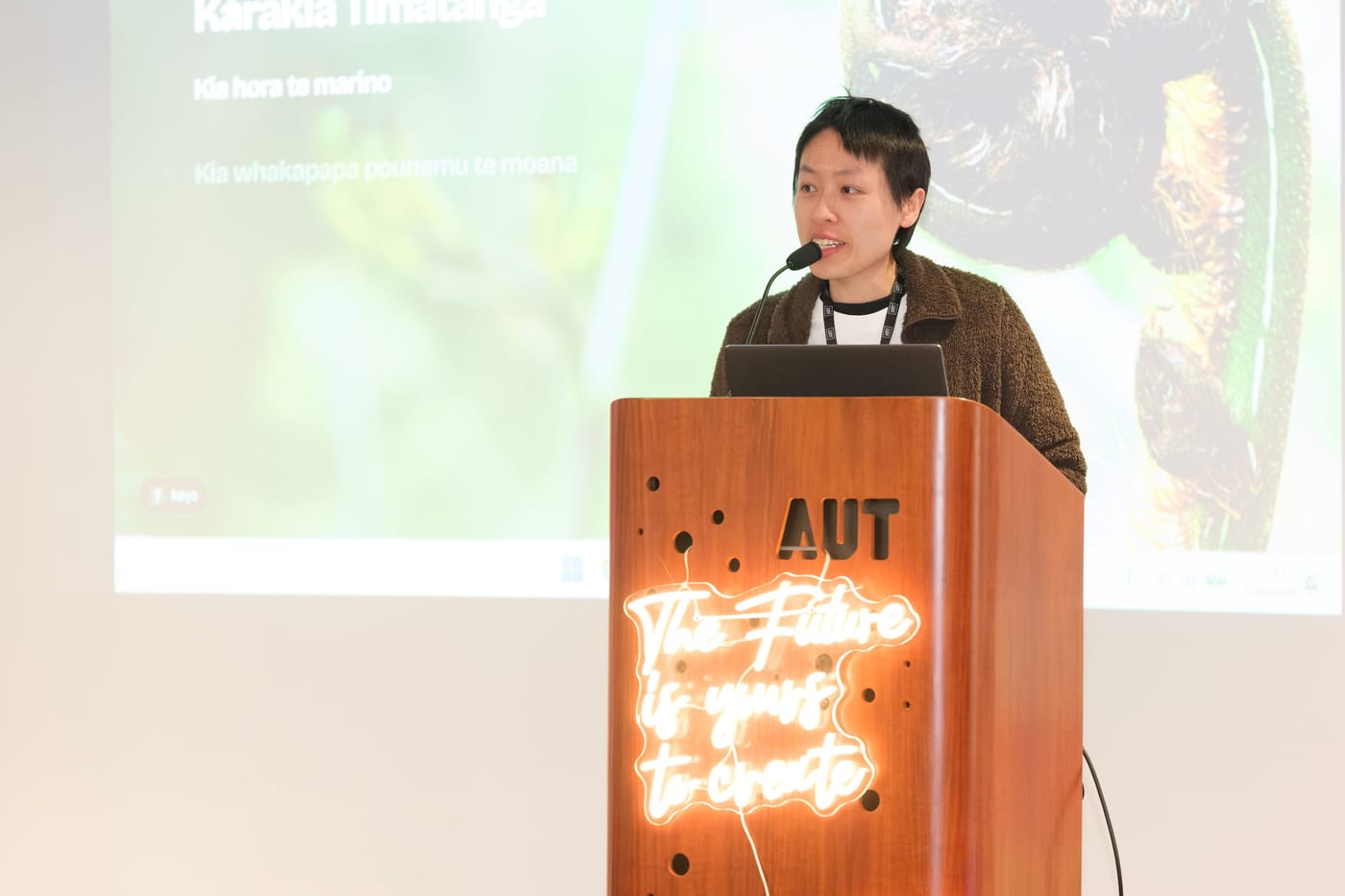 Chan Meng at the AUT podium during the Karakia Tīmatanga that opened the festival
